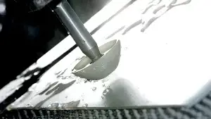 Water jet cutting process on a flat material sheet for custom component production.