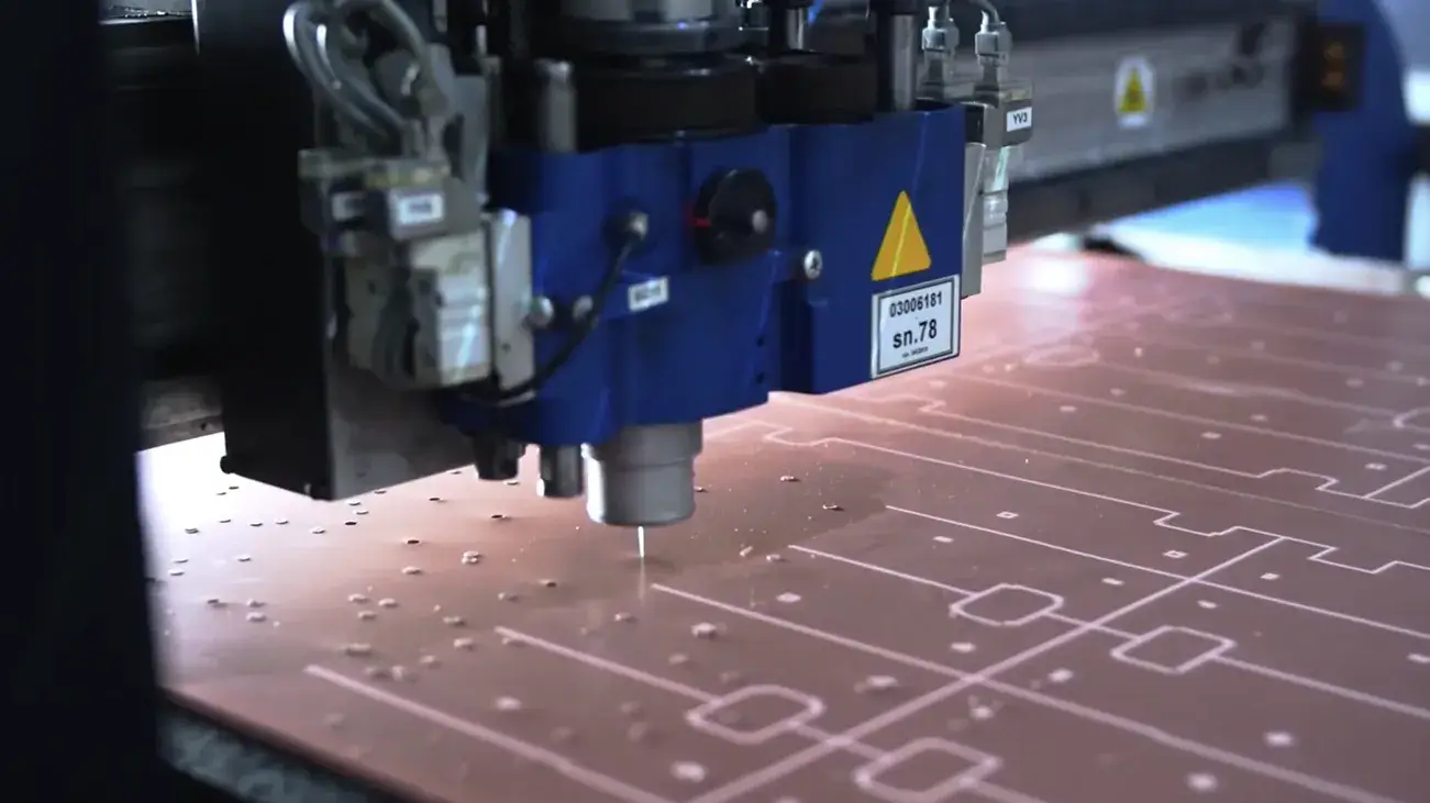Close-up of a digital plotter performing kiss-cutting on adhesive-backed EMI gaskets.