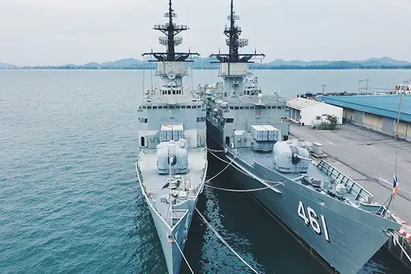Two naval military frigates sailing together on the open sea during naval operations.
